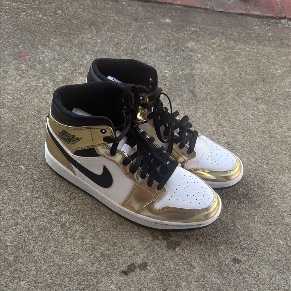 Gold and White Jordan 1s Mids.